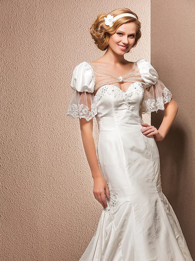 Full length view of a bride in a taffeta wedding dress.