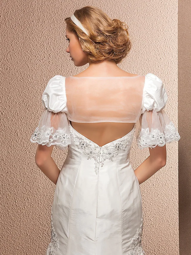 Bride posing in a sleeveless wedding dress.