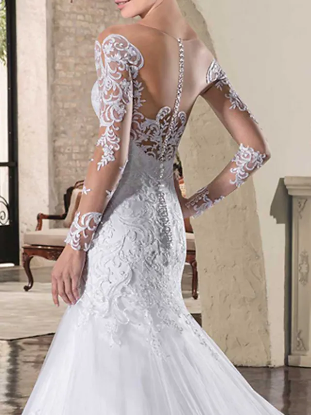Full length view of the mermaid trumpet wedding dress with its flowing court train.