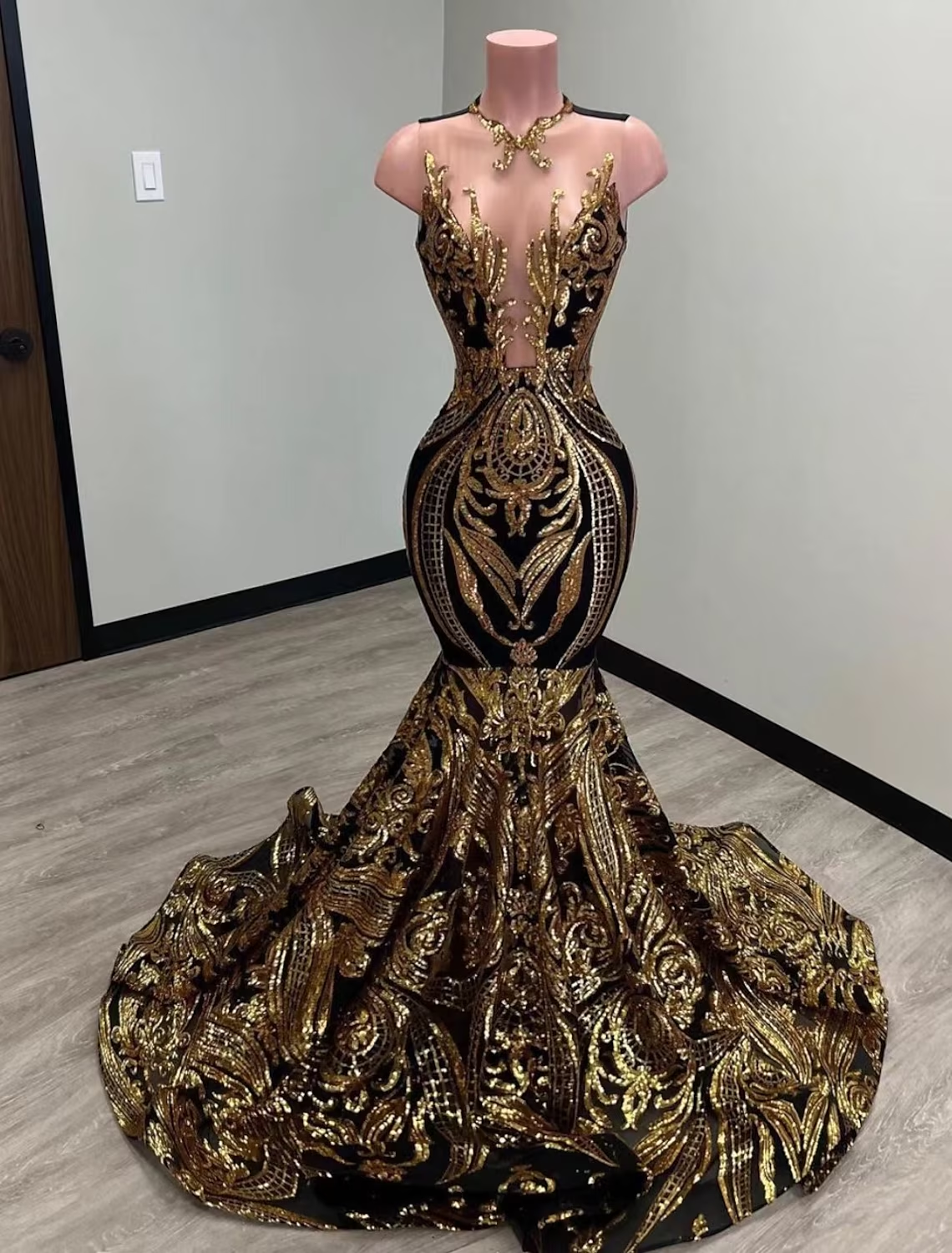 Elegant sequined mermaid evening gown with illusion neckline and court train on a model.