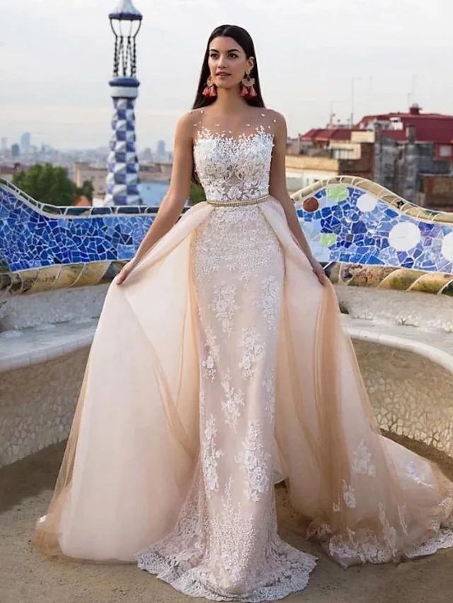 Elegant mermaid trumpet wedding dress with jewel neck and lace appliques.