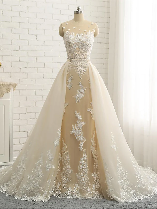 Close-up of lace and pearl appliques on a formal bridal gown.