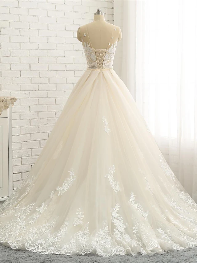 Full length view of a bride in a jewel neck lace wedding dress.