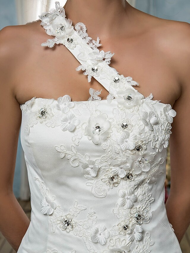 Detail of the one-shoulder neckline and beaded embellishments on the gown.