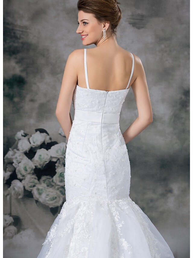 Back view of a white mermaid wedding gown with chapel train and beading.