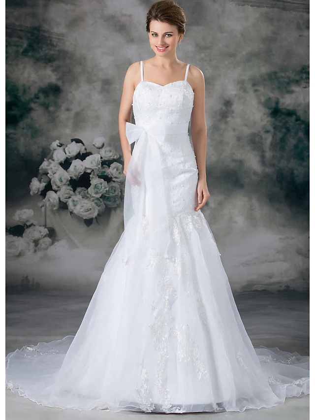 Full length view of a mermaid trumpet wedding dress with flowing chapel train.
