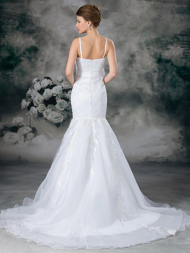 Detailed view of the lace and organza fabric on an elegant bridal gown.