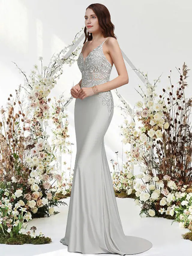 Model wearing an elegant Mermaid Trumpet V-Neck Chiffon Gown with appliques and a sweep train.