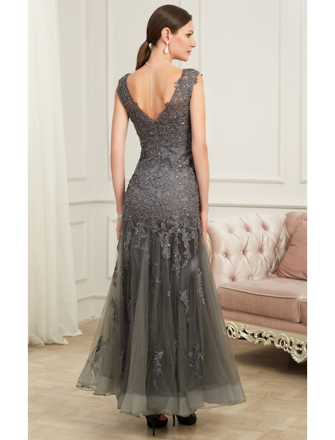Back view of a woman in a floor-length mermaid trumpet gown with sequin details.