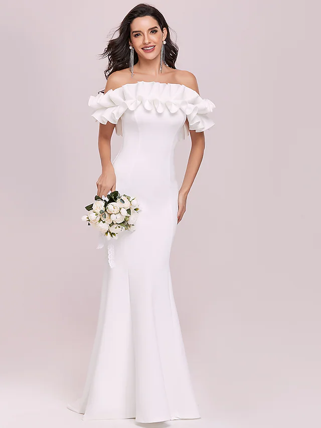 Side view of a bride wearing a mermaid trumpet wedding dress with off-shoulder design.
