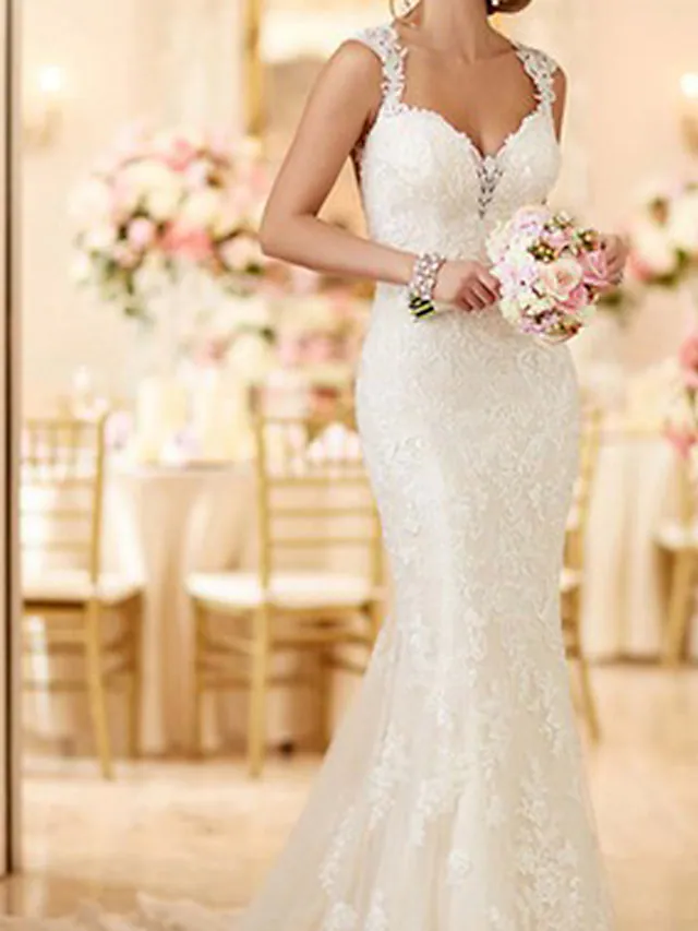 Backless mermaid wedding dress with lace details and spaghetti straps.