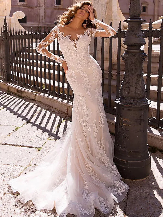 Close-up of V-neck lace bodice and illusion long sleeves on a wedding dress.
