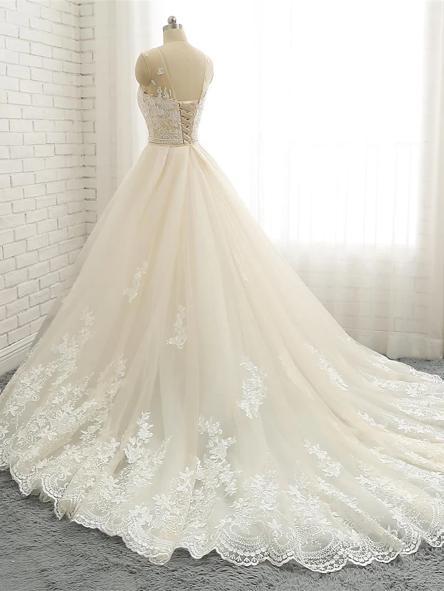 Back view of a mermaid wedding gown showing chapel train and delicate lace details.
