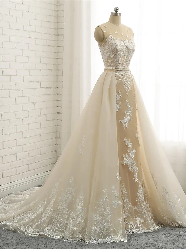 Close-up of the jewel neck and lace appliques on a bridal gown.