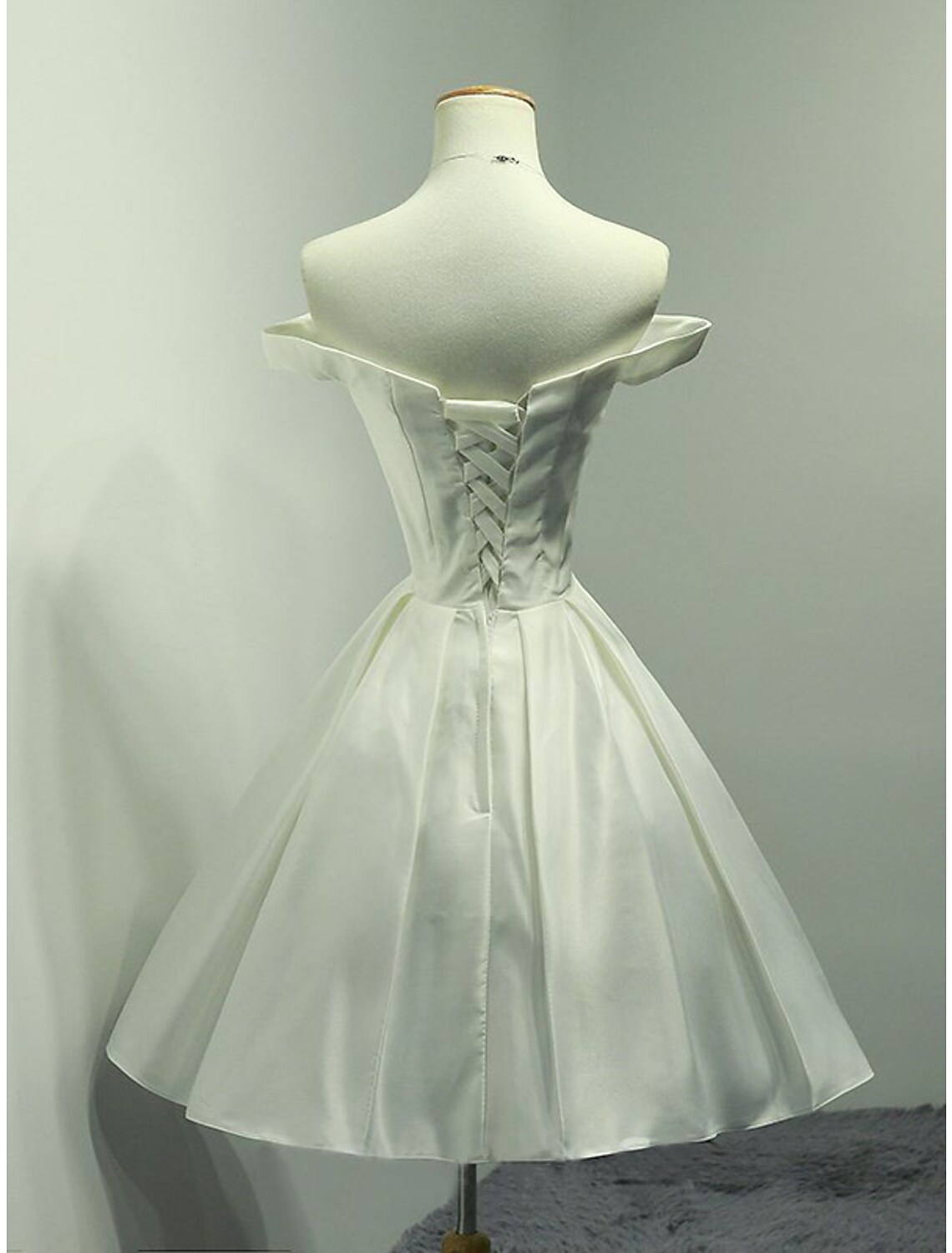 Minimalist A-line off-shoulder satin knee-length dress, side view.