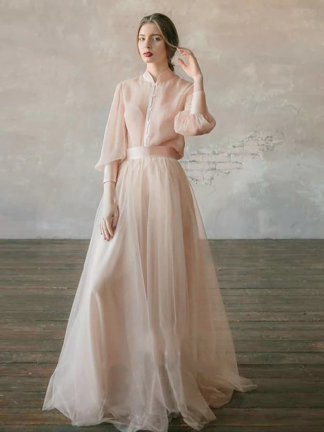 Model wearing an elegant two-piece empire waist long sleeve chiffon dress with a stand collar and tiered skirt.