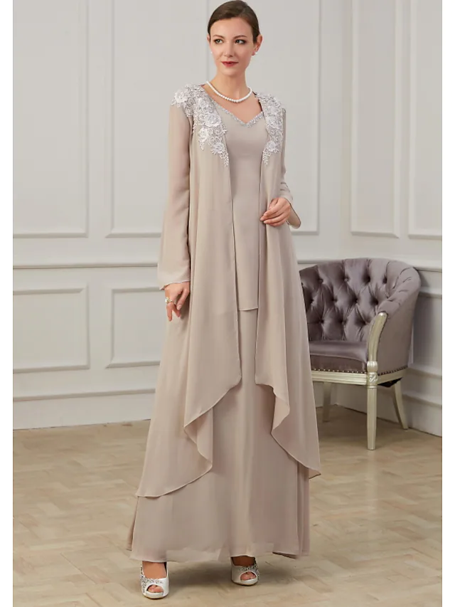 Woman in elegant navy A-line mother of the bride dress with long sleeves and appliques.