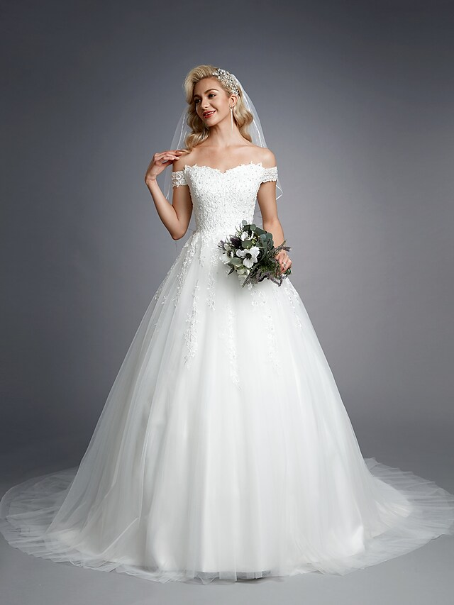Bride wearing off-shoulder short sleeve ball gown.