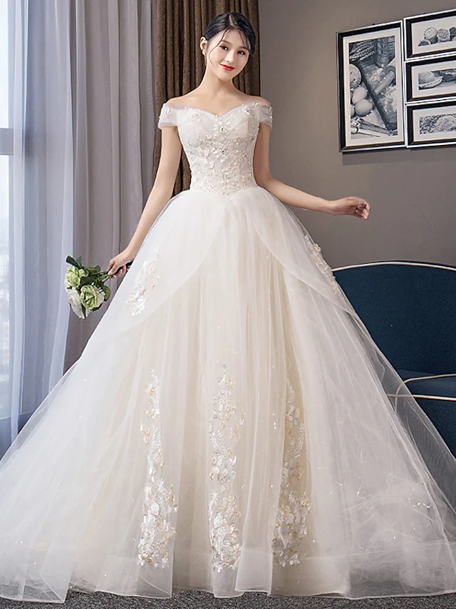 Elegant off-shoulder ball gown wedding dress with cap sleeves.
