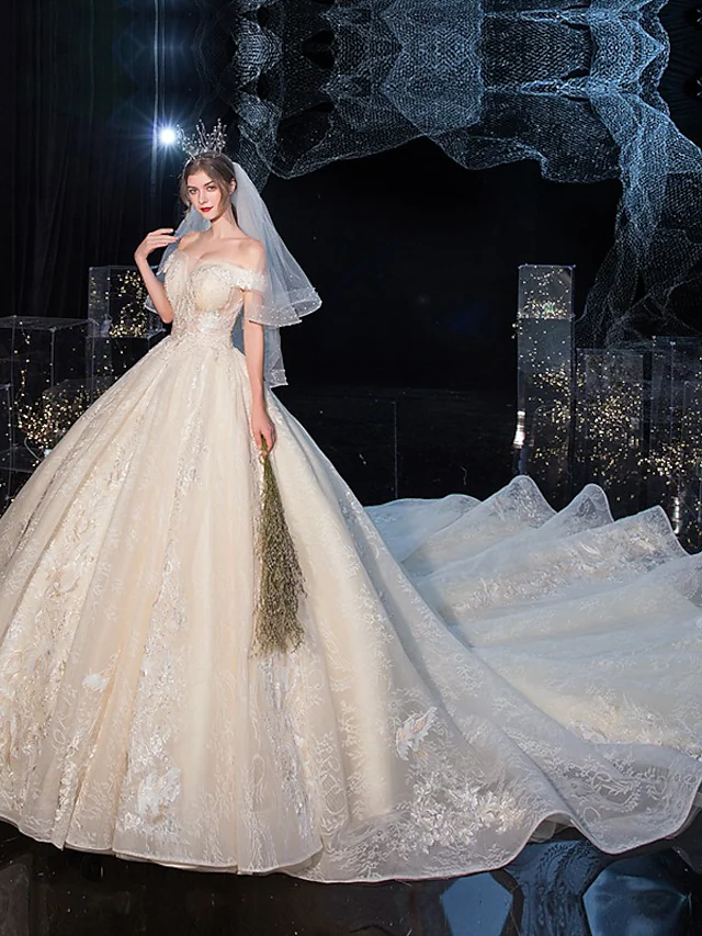 Elegant off-shoulder ball gown wedding dress with cathedral train and lace details.