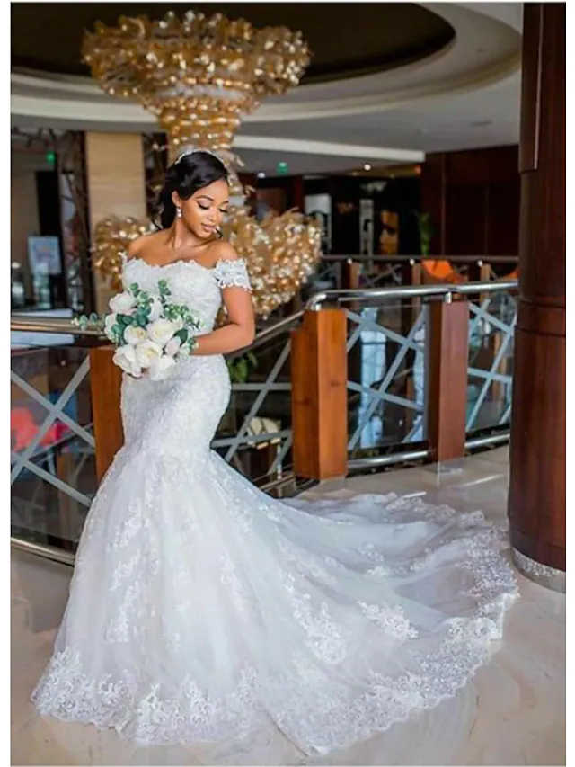 Back view of off-shoulder mermaid wedding dress, showcasing lace appliques and chapel train.