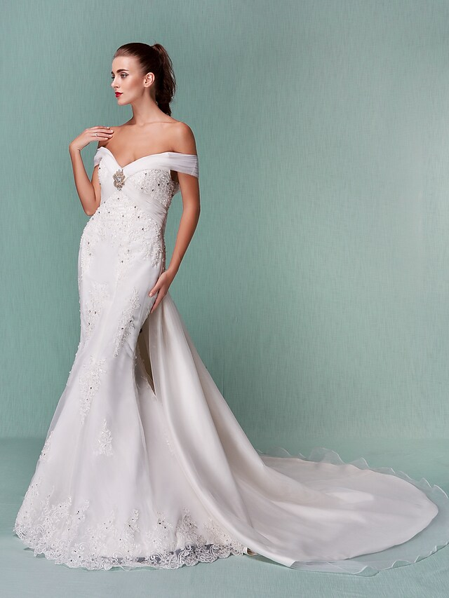 Detail of the off-shoulder neckline and short sleeve on a white wedding gown.