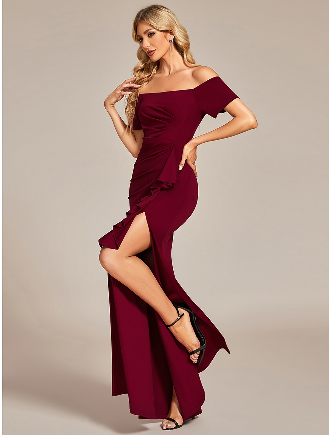 Full-length view of a black off-shoulder ruched maxi dress.