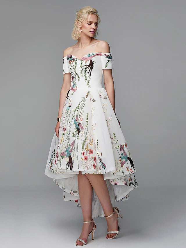 Side view of a woman in a flowing off-shoulder embroidered maxi dress.