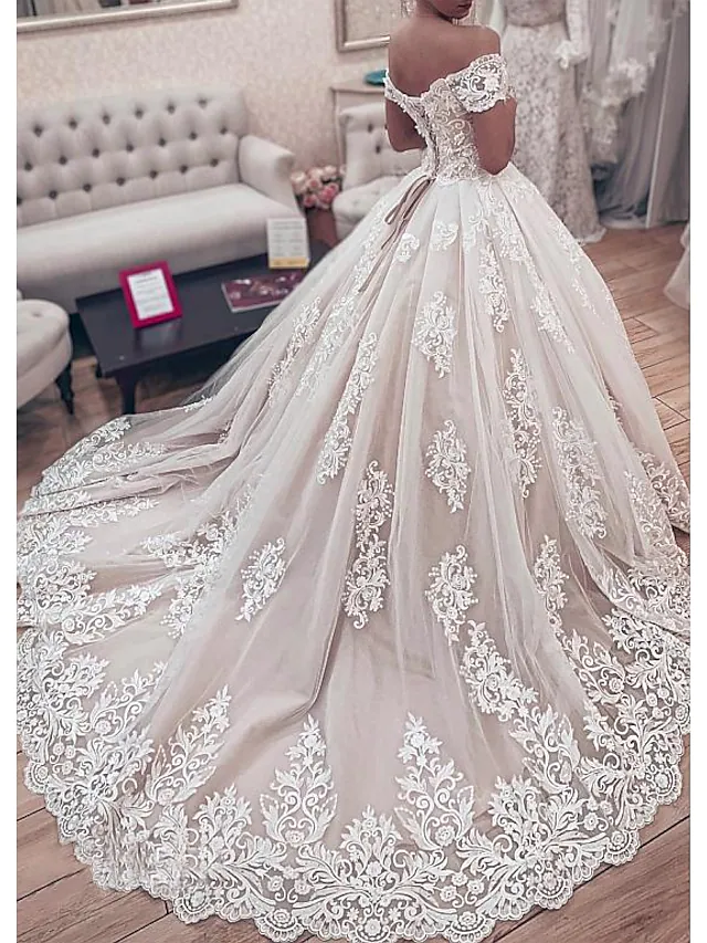 Back view of an off-shoulder ball gown wedding dress showing the chapel train and lace appliques.
