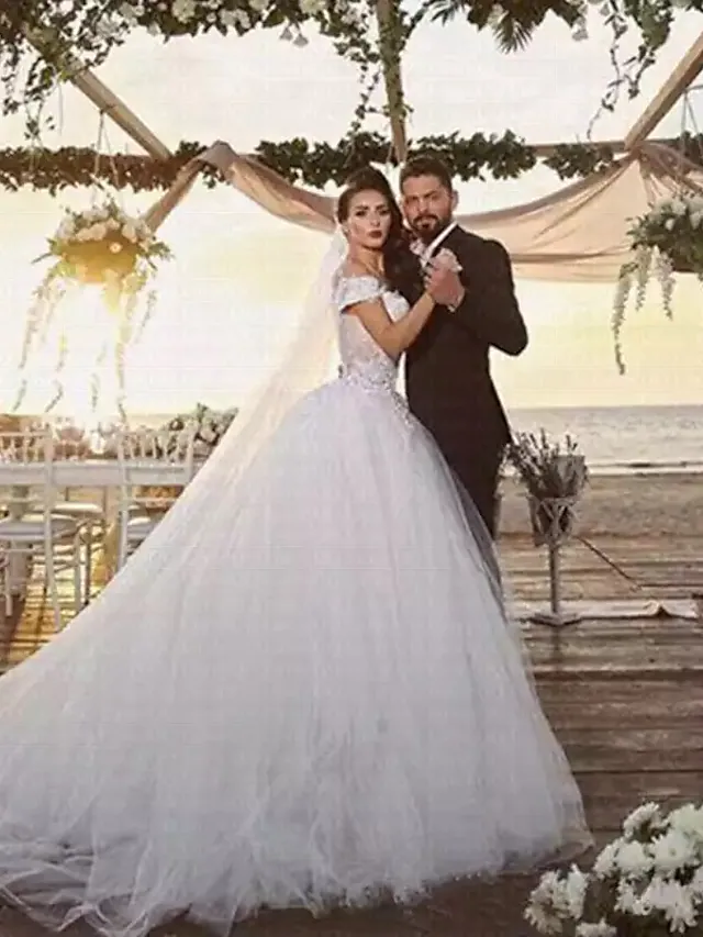 Side view of the off-shoulder ball gown wedding dress with lace details.