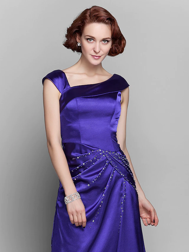 Elegant off-shoulder Mother of the Bride dress with beading and side draping.