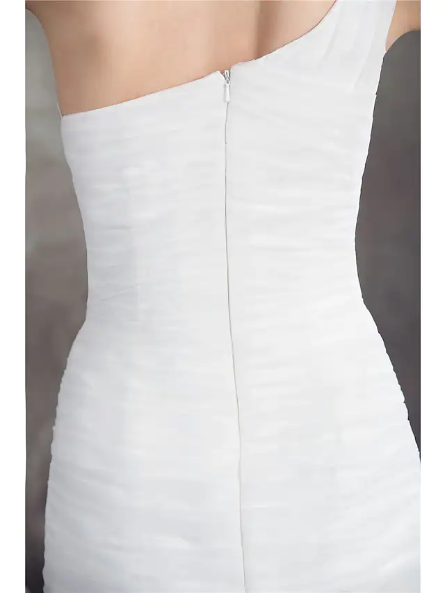 Close-up of ruched appliques and one-shoulder detail on bridal dress.