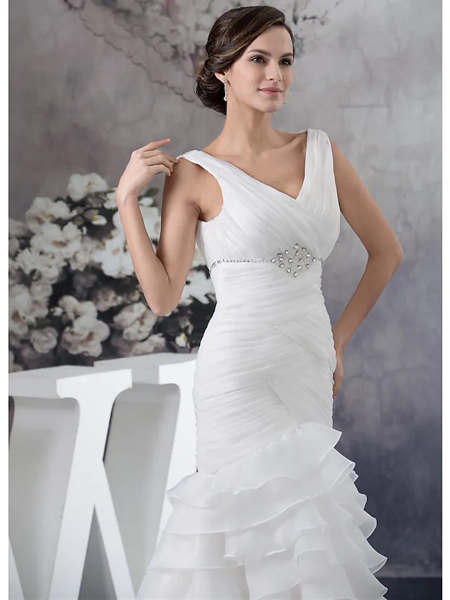 Close-up of ruched beading and delicate ruffles on an organza wedding gown.