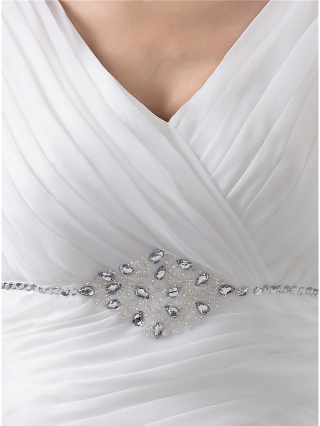 Full length view of a bride wearing a V-neck organza wedding dress.