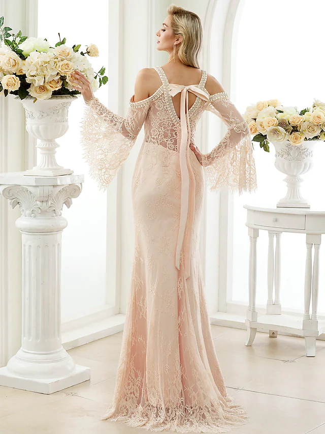 Back view of white wedding dress showing open back and floral lace details.