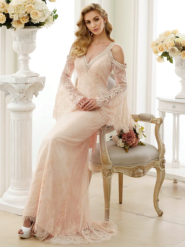 Side view of white wedding dress with train, floral lace, and crystal embellishments.