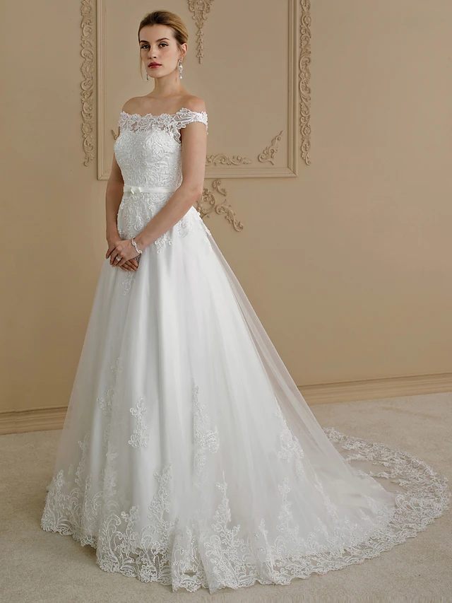 Elegant plus size bride in an off-shoulder lace tulle ball gown wedding dress with a court train.