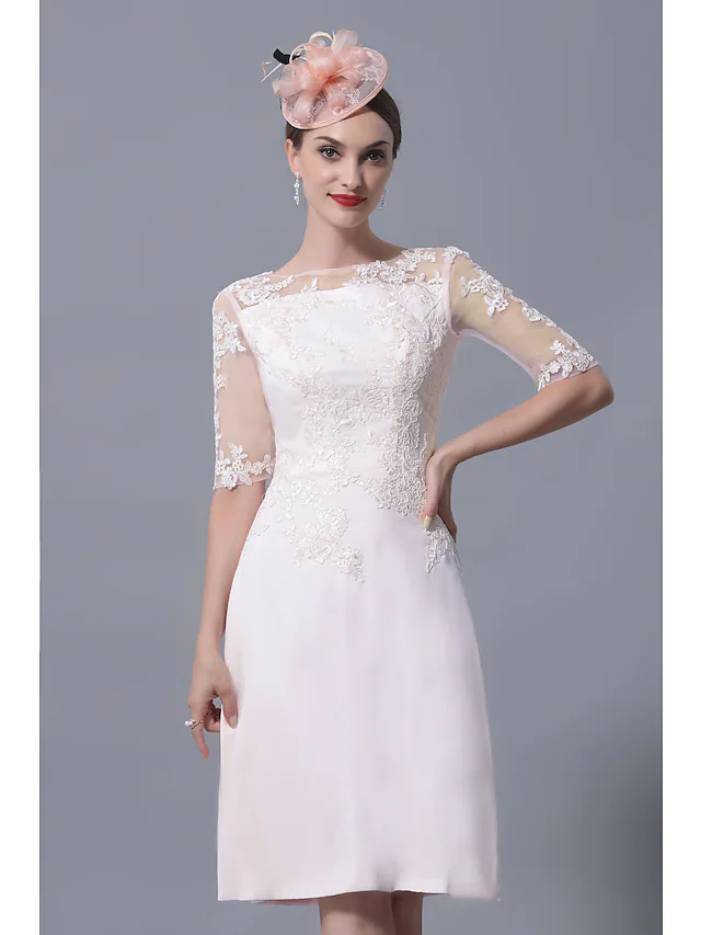 Woman posing in the sophisticated knee-length Mother of the Bride gown.