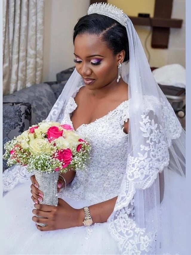 Close-up of the V-neckline and lace appliques on the ball gown wedding dress.