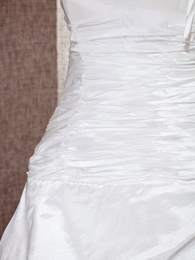 Detail of the one-shoulder design on a wedding dress.