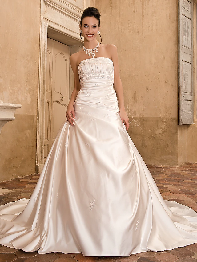 Princess A-line wedding dress with strapless satin bodice and chapel train.