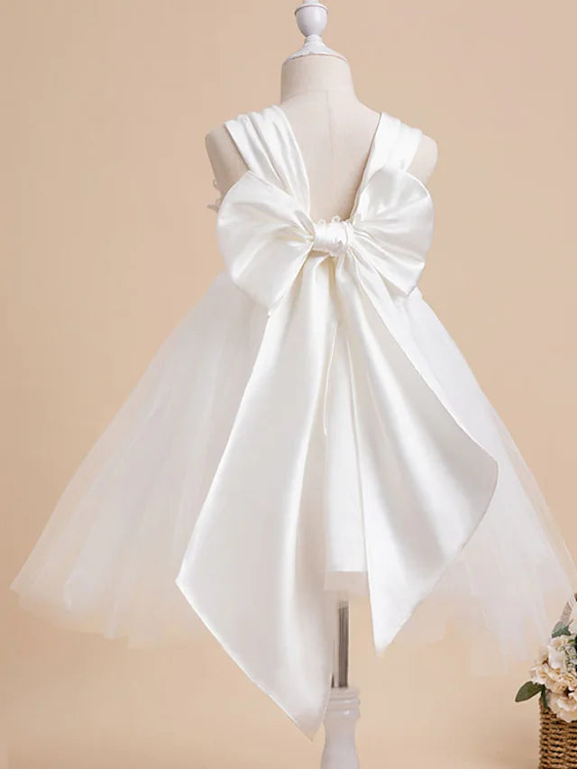 Close-up of the jewel neckline and bow detail on the elegant flower girl dress.