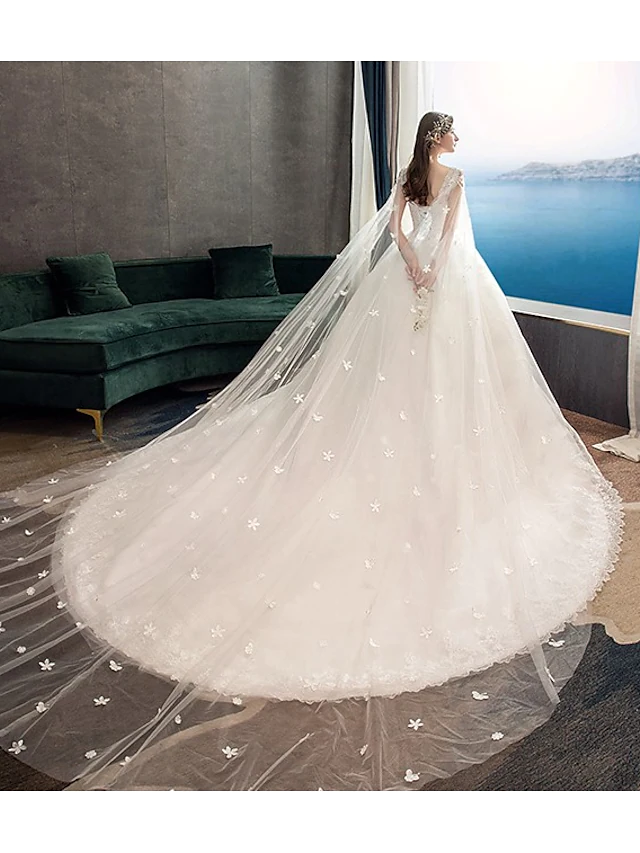 Side view of the princess ball gown wedding dress, showcasing the chapel train and voluminous tulle skirt.