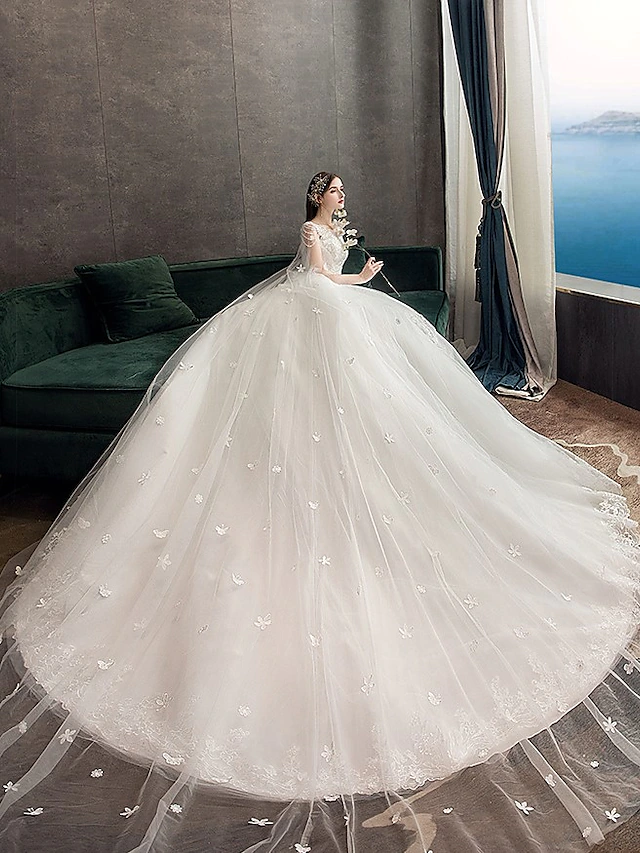 Full length view of the luxurious white wedding dress, featuring a voluminous tulle skirt and elegant silhouette.