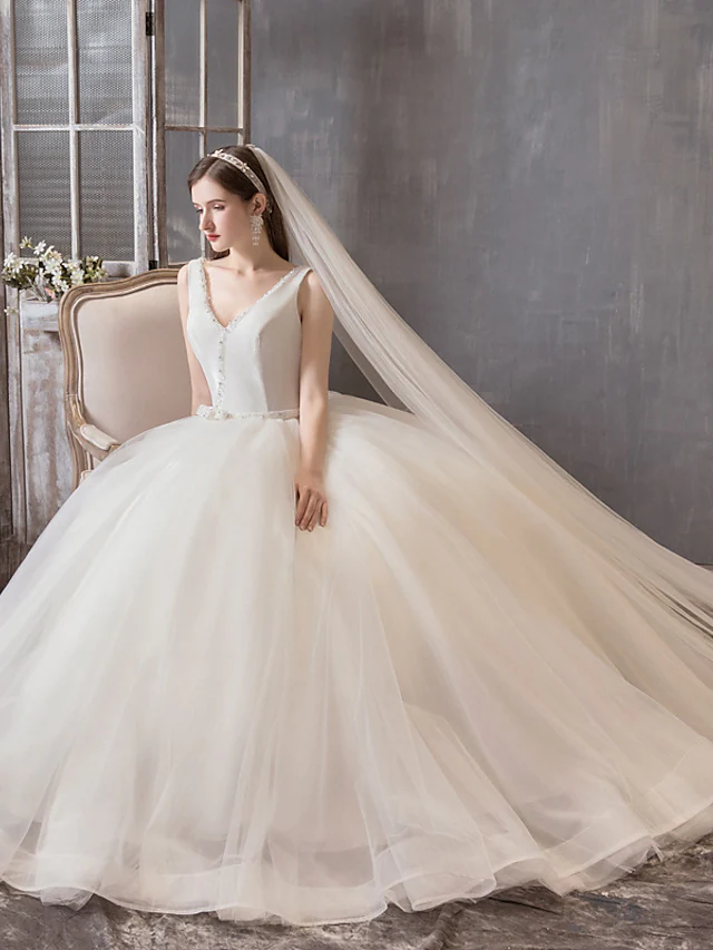 Side profile of the bride wearing the luxurious floor-length wedding dress.