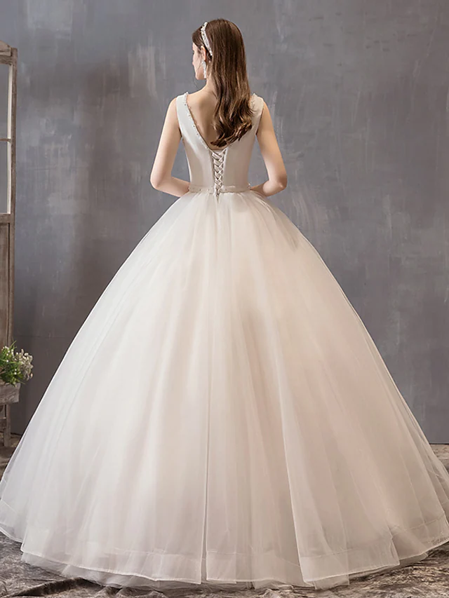 Detail of the delicate bow and beading on the waist of the white wedding gown.