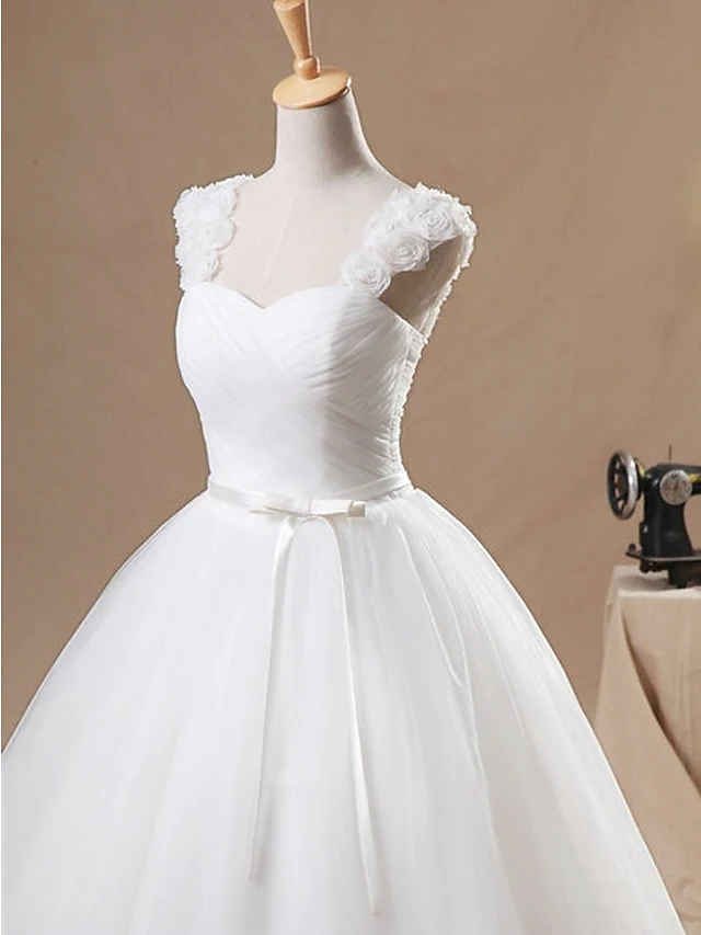 Close-up of ruched bodice and appliques on a bridal ball gown.