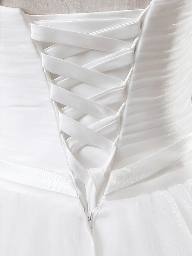 Full view of a bride wearing a jewel neck ball gown.