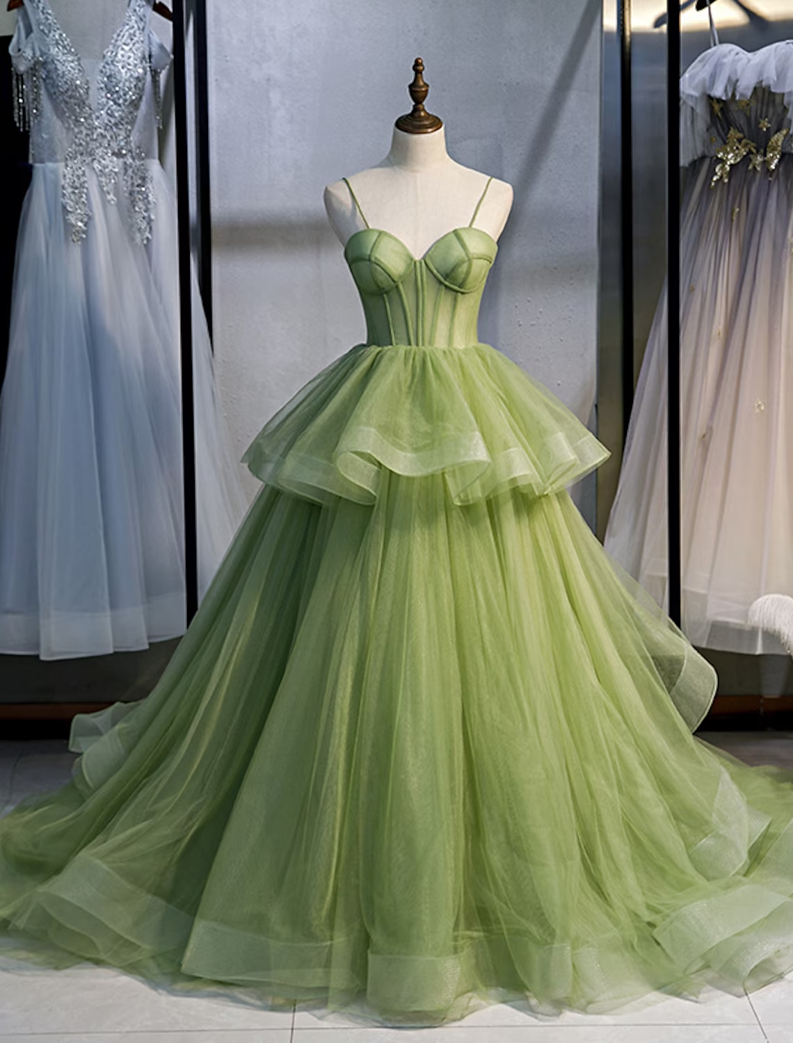 Elegant light blue ball gown Quinceanera dress with spaghetti straps and ruffled tulle skirt.