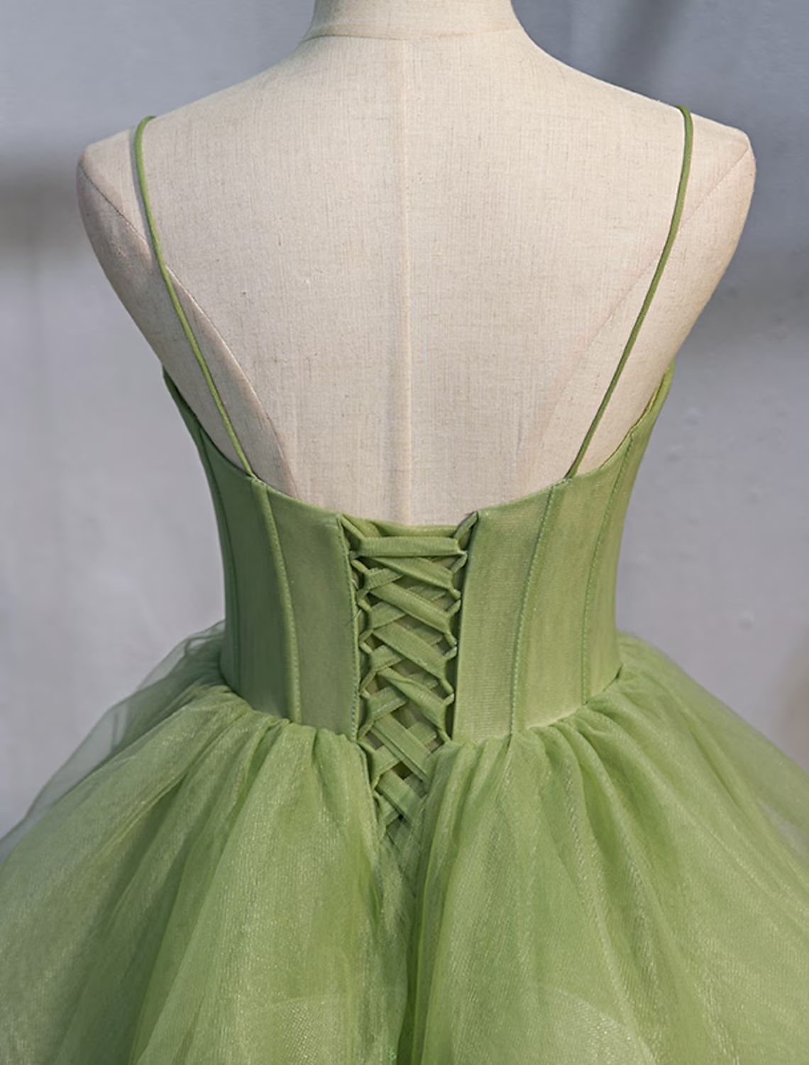 Close-up of the spaghetti strap bodice and ruffled tulle details on a Quinceanera dress.